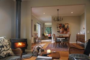 a living room with a fireplace and a dining room at Boyanda at Ferny Creek in Ferny Creek