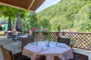 a restaurant with tables and chairs on a patio at Hotel Le Bellevue in Saint-Hippolyte