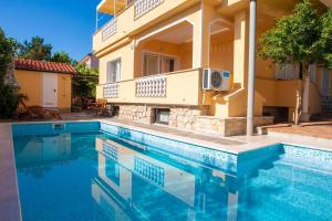 a swimming pool in front of a house at Pension Tina Appartement 2 in Šilo