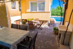 a patio with a table and chairs and a pool at Pension Tina Appartement 2 in Šilo
