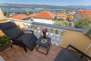 a balcony with two chairs and a table with flowers on it at Pension Tina Appartement 2 in Šilo +14 photos