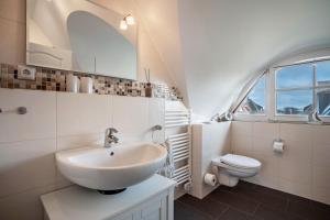 a white bathroom with a sink and a toilet at Ferienhaus Seeschwalbe 14 in Ummanz +28 photos