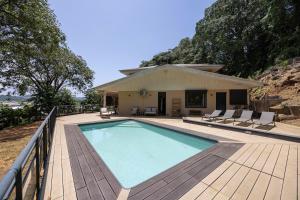 a swimming pool with chairs and a house at Grande villa 4 chambres avec piscine in Rémire-Camp