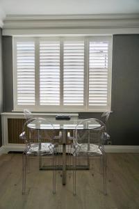 - deux chaises et une table dans une chambre avec fenêtre dans l'établissement Chelsea Prime Location Studio, à Londres 3 autres photos