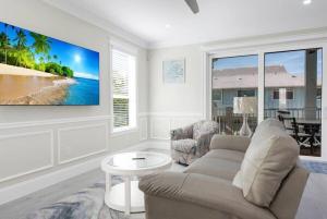 a living room with a couch and a tv on a wall at AMI Beach Oasis in Bradenton Beach
