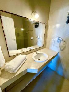 a bathroom with a sink and a large mirror at Apartamento Mãe África Centro Morro de São Paulo in Morro de São Paulo