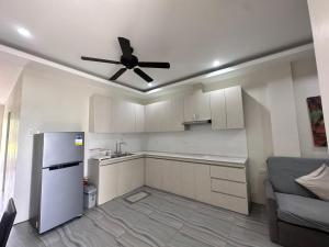 a kitchen with a refrigerator and a ceiling fan at Kristinas Aparthotel Kabankalan in Kabankalan