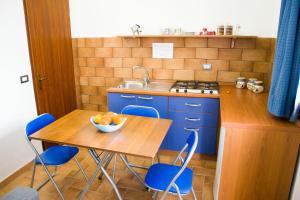 a kitchen with blue cabinets and a table with a bowl of fruit at Wohnung 4 Studio in Cattolica Eraclea
