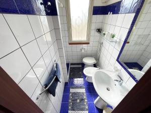 a blue and white bathroom with a toilet and a sink at Wohnung 4 Studio in Cattolica Eraclea