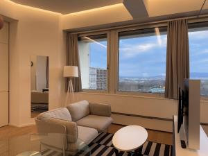 - un salon avec une chaise et de grandes fenêtres dans l'établissement Luxury City Apartment with Skyline View, à Vienne