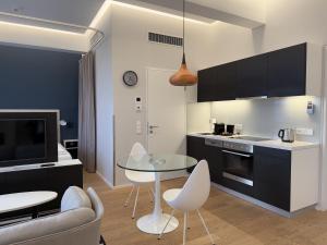 une cuisine avec une table en verre et des chaises dans une pièce dans l'établissement Luxury City Apartment with Skyline View, à Vienne