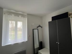ein Badezimmer mit Spiegel, Kommode und Fenster in der Unterkunft la Sainterie in Savonnières