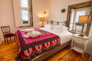 ein Schlafzimmer mit einem Bett mit einer rot-weißen Decke in der Unterkunft Ferienhaus für 2 Personen ca 43 qm in Algarvia, Azoren Sao Miguel in Algarvia