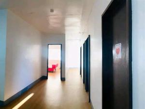 a hallway with doors and a red couch in a building at WJV Inn San Carlos in San Carlos