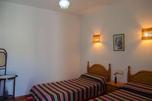 a bedroom with two beds and two lights on the wall at Casa Número 6 in Válor