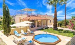 a villa with a swimming pool and a house at Ferienhaus Für 12 Personen In Episkopi, Kreta West Kreta in Episkopí- Rethimno