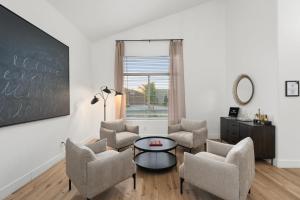 a living room with chairs and a table and a chalkboard at The Cardinal Walk to Stadium Pool+Spa Sportcourt in Glendale