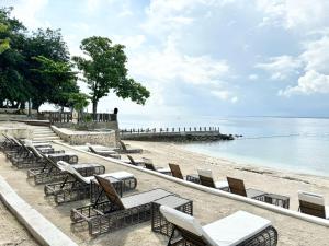 a row of chairs and tables on a beach at Family-Friendly Condo Unit in Lapu Lapu City