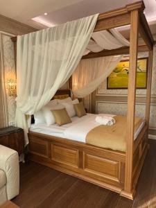 um quarto com uma cama de dossel e cortinas brancas em Hotel Kerber em Podgorica