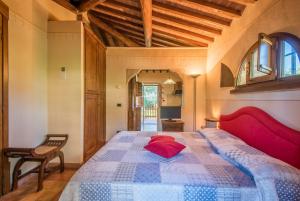 a bedroom with a large bed with a red pillow at Appartamento il Pino in Rapolano Terme +22 photos