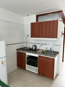 a kitchen with a sink and a microwave at Temporario Alfonso I in Santa Fe +6 photos