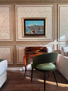 uma sala de estar com um piano e uma cadeira verde em Hotel Kerber em Podgorica