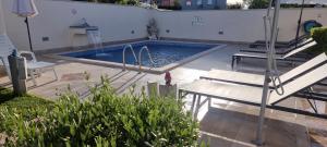a swimming pool with two chairs and a table at Apartment Sanja in Kaštel