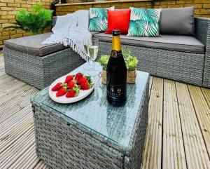 eine Flasche Wein und ein Teller mit Obst auf einem Tisch in der Unterkunft Stunning Apartment -Quick Access to Central London in Ealing + 19 Fotos