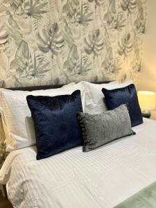 ein Bett mit zwei blauen Kissen darauf in der Unterkunft Stunning Apartment -Quick Access to Central London in Ealing