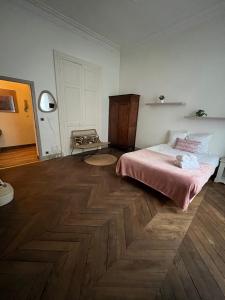 a bedroom with a bed and a wooden floor at Appartment Doutre Terrasse- 2ch in Angers