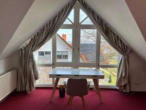 a table in a room with a large window at Familiensuite in Villa in Hildesheim
