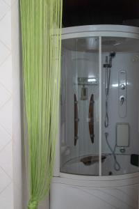 a shower with a green curtain in a bathroom at Thodorou Sunset Villa in Stalos +32 photos