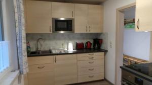 a kitchen with a sink and a microwave at Fewo Am Skihang Eg in Eibenstock