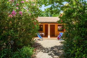 una casa tra gli alberi con un giardino di Trilo Begonia a Marina di Grosseto