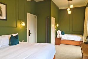 a bedroom with green walls and two beds in it at The Alyth Hotel in Alyth