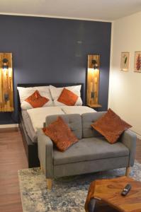 a bedroom with a bed and a couch with pillows at Apartment 17 in Kassel