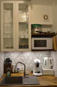 a kitchen with white cabinets and a sink and a mixer at Apartment 17 in Kassel +20 photos