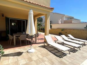 a patio with a table and chairs and an umbrella at Ferienhaus Sommerflucht 2 in Barbat na Rabu
