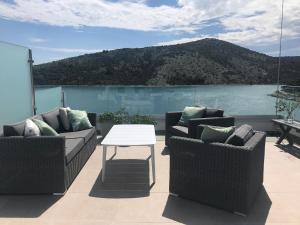 a patio with two couches and a table and a mountain at Apartment White House in Vinišće +7 photos