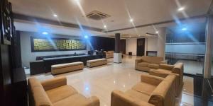 a large room with couches and a piano at Grage Hotel Malang by TOS in Malang