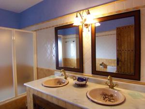 a bathroom with two sinks and a large mirror at Casa Número 7 in Válor