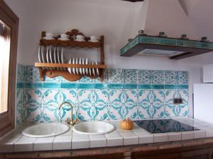 two sinks in a kitchen with blue and white tiles at Casa Número 7 in Válor
