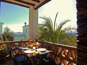a table on a balcony with a view of the ocean at Casa Número 7 in Válor