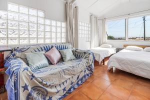 a living room with a couch and two beds at Saude Beach House in Costa da Caparica