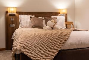 - un grand lit avec une couverture et des oreillers dans l'établissement Cropton Lodge at Galtres Retreat, à Pickering