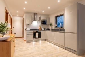 Il comprend une cuisine avec des appareils en acier inoxydable et du parquet. dans l'établissement Cropton Lodge at Galtres Retreat, à Pickering