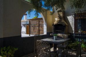 a table and chairs in a patio with a fireplace at Casa Número 5 in Válor