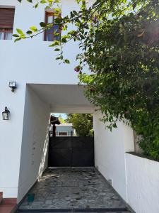 eine Auffahrt, die zu einer Garage mit einem schwarzen Tor führt in der Unterkunft Casa del Bicentenario in Tandil