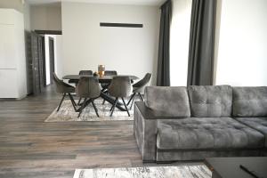 a living room with a couch and a table at Kintų Perlas Villa 4B in Kintai