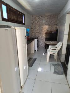 a kitchen with a table and a refrigerator at Sua casa no litoral III in Luis Correia